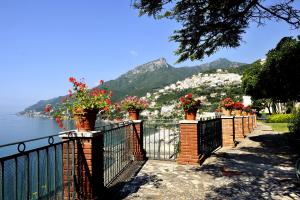 a fence with flowers on it next to the water at Villa Maria Antonietta in Vietri sul Mare