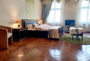 um quarto com uma cama grande e piso em madeira em Ratusha Apartments em Lviv