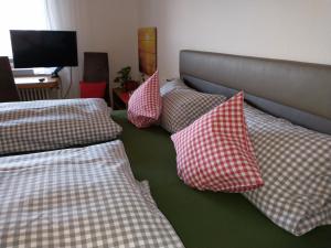 Ferienhaus Keller في Lippertsreute: مجموعة من الوسائد على سرير في غرفة