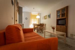 sala de estar con sofá naranja y mesa en Robs House, en Riomaggiore