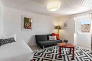 a bedroom with a bed and a couch and a table at Ana's House in Óbidos
