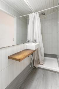 a bathroom with a sink and a shower curtain at Ana's House in Óbidos