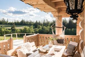 - une terrasse couverte avec une table en bois et un hamac dans l'établissement Domek Góralski Niedźwiedzia Gawra, à Poronin