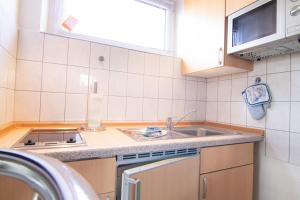 a small kitchen with a sink and a stove at hausANNA - casaNAUTICO in Ueckermünde +191 photos