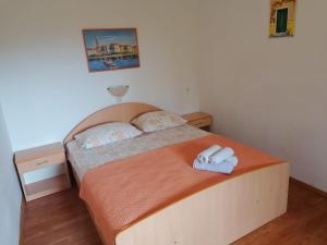 ein Schlafzimmer mit einem Bett mit zwei Handtüchern darauf in der Unterkunft Apartments Piko2 in Jelsa