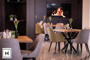 a restaurant with tables and chairs and a fireplace at Martini Restaurant & Cazare in Sebeşel
