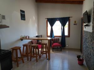 kuchnia ze stołem i krzesłami oraz oknem w obiekcie Cabaña los Hielos w mieście El Calafate