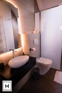 a bathroom with a white sink and a toilet at Martini Restaurant & Cazare in Sebeşel