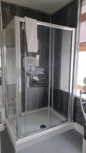 um chuveiro com uma porta de vidro na casa de banho em The Renishaw Rooms em Renishaw