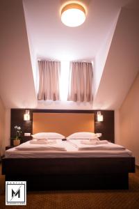 a bedroom with a large bed with a window at Martini Restaurant & Cazare in Sebeşel