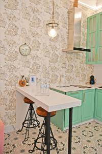 kuchnia z zielonymi szafkami i stołem ze stołkami w obiekcie Apartamentos El Mar Azul 5 El Bajondillo Torremolinos w mieście Torremolinos +26 zdjęć