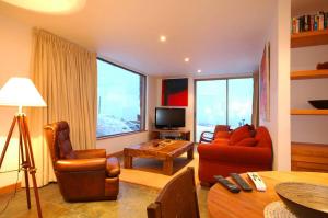 a living room with a couch and chairs and a television at Casa Farellones Lower Apartment in Farellones