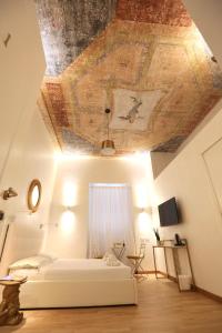 a bedroom with a ceiling with a painting on it at KISS ME ROME Luxury Rooms in Rome