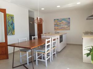 a kitchen with a wooden table and chairs at CASA PISCINA DOCTOR FLEMING 51 in Llubí