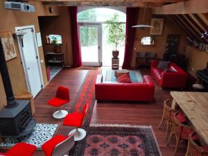 a living room with red furniture and a fireplace at Todo Se Pasa Yurt 2 in Sauwerd