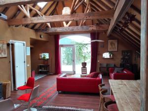 a living room with a red couch and a table at Todo Se Pasa Yurt 2 in Sauwerd