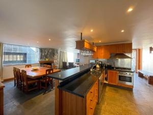 a large kitchen with a table and a dining room at Casa Farellones Lower Apartment in Farellones