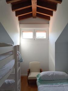a bedroom with a bunk bed and a chair at Dúplex en Comillas in Comillas