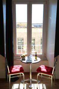 einen Tisch und zwei Stühle vor einem Fenster in der Unterkunft KISS ME ROME Luxury Rooms in Rom