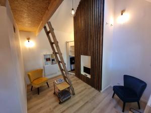 sala de estar con escalera y silla en La Grange de l'Aber Ildut, en Brélès