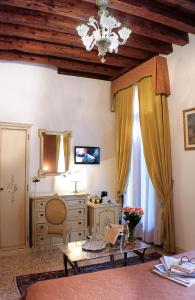 a living room with a table and a dresser at Apostoli Palace in Venice
