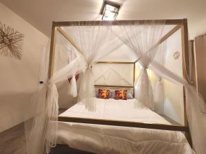 um quarto com uma cama de dossel com cortinas brancas em Westeros - GoT Themed Cabin in the Olympic Forest. em Forks
