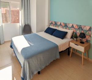 sypialnia z łóżkiem z niebieskim kocem i stołem w obiekcie Apartamento Playa Espejo w mieście Los Alcázares +12 zdjęć
