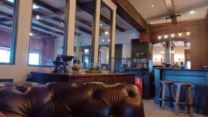 a living room with a leather couch and a bar at The Renishaw in Renishaw