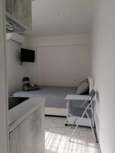 a small white room with a bed and a chair at Посуточно мини-студия метро Дорогожичи Киев in Kyiv