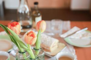 zwei Vasen voller roter Blumen auf dem Tisch in der Unterkunft Bauernhof Kure in Leutschach