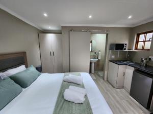 ein Schlafzimmer mit einem großen weißen Bett mit Handtüchern darauf in der Unterkunft Cozy and Comfort in Harrismith