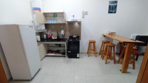 a kitchen with a refrigerator and a table and chairs at Cabaña los Hielos in El Calafate