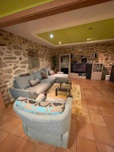 sala de estar con sofá y pared de piedra en Casa con vistas a Portugal, en Arbo