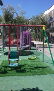 un parque infantil con columpios en el césped en Residence Jolly, en Peschici