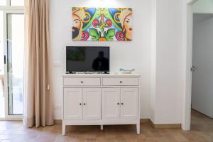 a white cabinet with a television on top of it at la finestra sul mare a marzamemi in Marzamemi