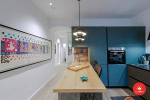 a kitchen with a wooden table and blue cabinets at Wild Zagara Garden View in La Spezia