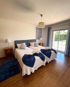 um quarto com 2 camas com almofadas azuis em Oliva House em Lagos