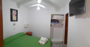 Habitación con cama verde y nevera. en Hotel Ciudad del Sol en Termas de Río Hondo