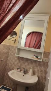 ein Bad mit einem Waschbecken und einem Spiegel in der Unterkunft La Casa di Milly in Sori
