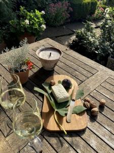 a wooden table with a cutting board and a wine glass at Altes Winzerhaus Lenz in Pünderich