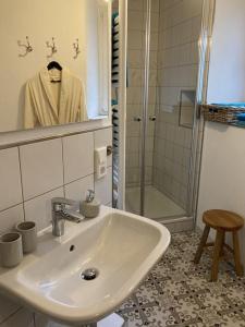 a white bathroom with a sink and a shower at Altes Winzerhaus Lenz in Pünderich