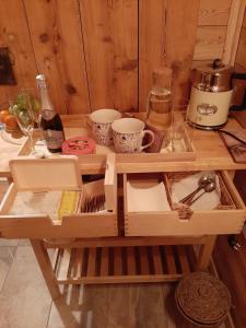 - une table en bois avec de la vaisselle et des tasses dans l'établissement Apartma kašča, à Domžale