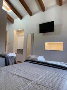 a bedroom with a bed and a flat screen tv at Hostal A Cantina de Renche in Renche