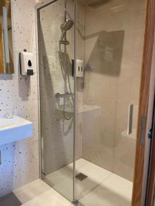 a shower with a glass door in a bathroom at Hostal A Cantina de Renche in Renche +14 photos