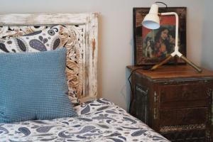 Una cama con una almohada azul y una lámpara en un tocador en Loft Design Typikindi en Douai