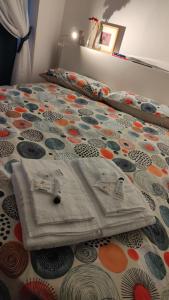 uma cama com um edredão e almofadas em La Casa di Milly em Sori