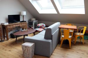 a living room with a couch and a table at Loft Design Typikindi in Douai