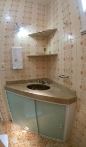 uma casa de banho com um lavatório e um espelho em Apartamento Cabo Frio em Cabo Frio