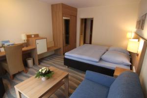 a small hotel room with a bed and a desk at Inselhotel Bruns in Norderney