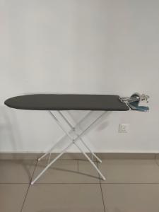 a white table with a black surfboard on it at The Second Homestay in Port Dickson